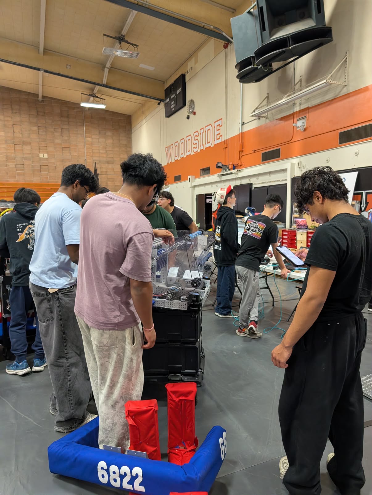The Shishkabots inspecting their robot during competition